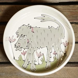 Grey scruffy dog design on grass with flowers on a medium dog bowl